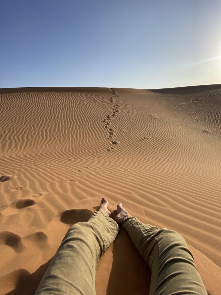 gambe di donna e impronte sulle dune del deserto del Merzouga